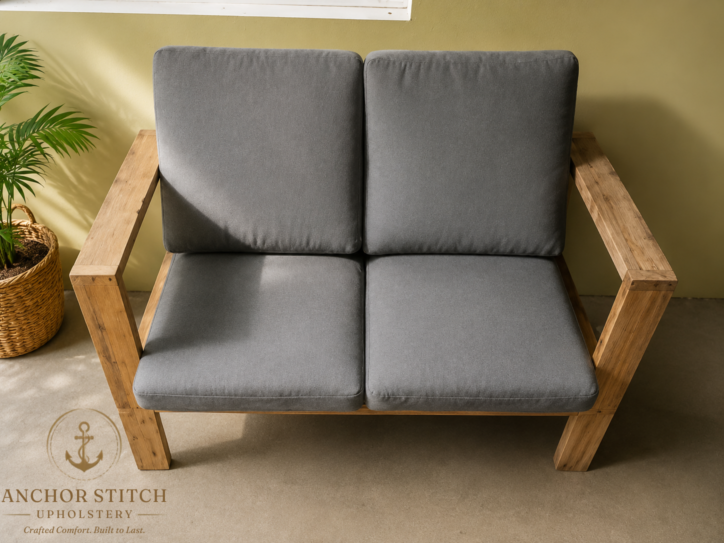 Custom grey cushions fitted to a timber outdoor loveseat on a sunny patio